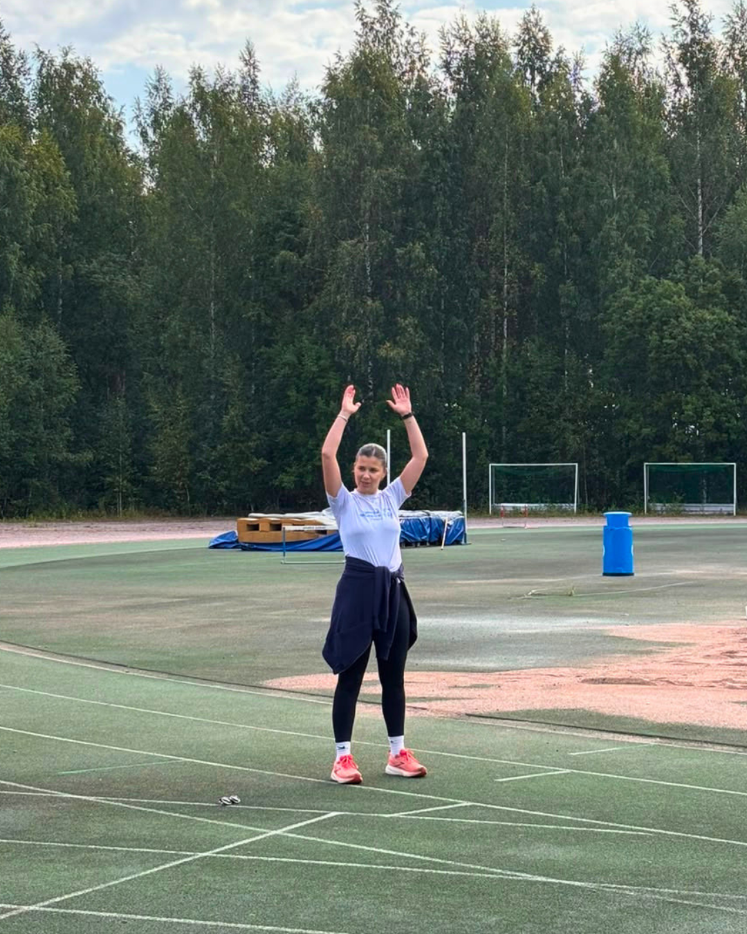 Yleisurheiluvalmentaja näyttämässä esimerkkiä seuraavasta liikkeestä.